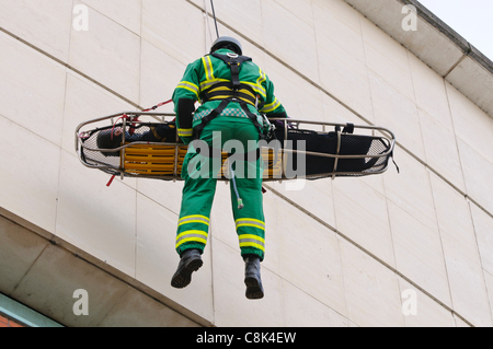 Ambulancier paramédical est ramené vers le bas d'un bâtiment sur une corde avec un patient pendant le lancement de l'Irlande du Nord Ambulance Service (NIAS) Équipe d'intervention en zone dangereuse (HART). Banque D'Images