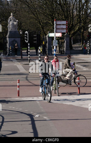 Les cyclistes traversant la jonction de route Vondelpark Amsterdam Hollande Pays-Bas Banque D'Images