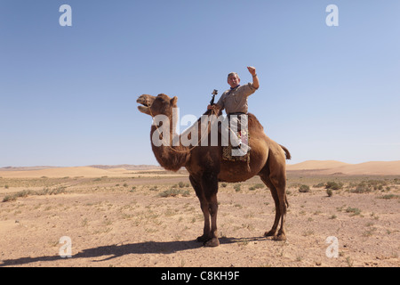 L'homme occidental monté sur un chameau dans le désert de Gobi en Mongolie Banque D'Images