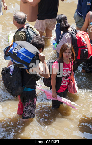 Personnes pataugeant dans l'eau d'inondation en centre-ville de Bangkok, Thaïlande Banque D'Images