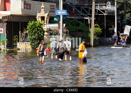 Personnes pataugeant dans l'eau des crues, Bangkok, Thaïlande Banque D'Images