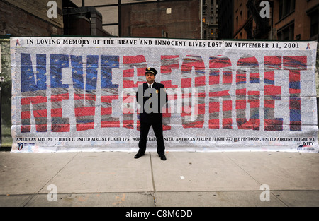 Un pompier se trouve en face de "ne jamais oublier" bannière à Ground Zero à New York sur le dixième anniversaire de l'attentat du 11 septembre Banque D'Images