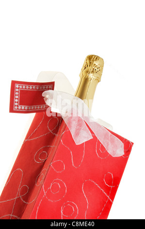 Bouteille de champagne dans un sac rouge avec ruban et gift tag isolés contre white Banque D'Images