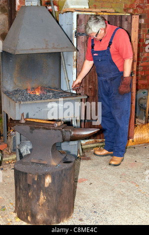 Le forgeron au travail à l'aide d'un acier forge portable typique et traditionnel de l'enclume en fer. Banque D'Images