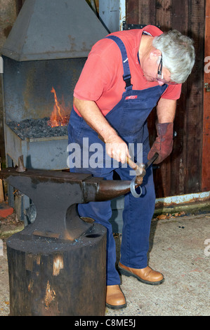 Le forgeron au travail à l'aide d'un acier forge portable typique et traditionnel de l'enclume en fer. Banque D'Images