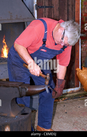 Le forgeron au travail à l'aide d'un acier forge portable typique et traditionnel de l'enclume en fer. Banque D'Images