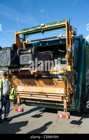 Les travailleurs refusent de Basildon Essex Conseil en travaillant à l'arrière de chargement et de vidange de la poussière panier wheely (sur roues) poubelles à l'arrière. Banque D'Images