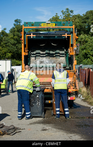 Les travailleurs refusent de Basildon Essex Conseil en travaillant à l'arrière de chargement et de vidange de la poussière panier wheely (sur roues) poubelles à l'arrière. Banque D'Images