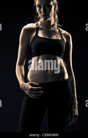 Femme athlétique grave dans les vêtements de sport Banque D'Images