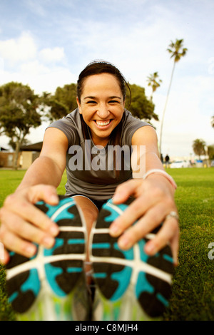 Hispanic woman stretching in park avant l'exercice Banque D'Images