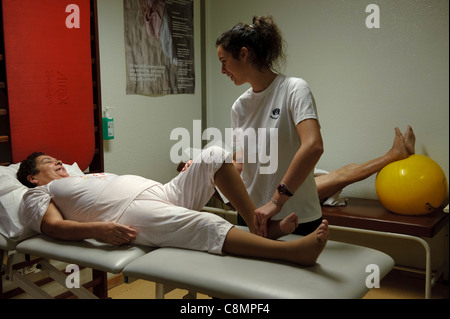 Physiothérapeute femelle aider un patient faire un exercice Banque D'Images