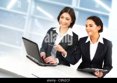 Image créative de two businesswomen working with laptop in office Banque D'Images