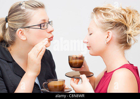 Portrait de deux jeunes femmes connaissant une délicieuse tasse de café. Banque D'Images