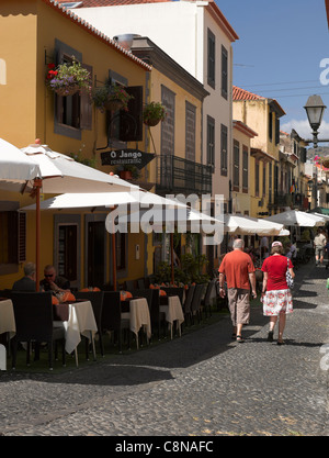 Couple plus âgé touristes visiteurs marchant devant des restaurants et des bars dans la vieille ville de Funchal Madeira Portugal eu Europe Banque D'Images