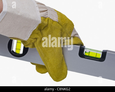 Un niveau sont tenues à la main avec des gants de protection Banque D'Images