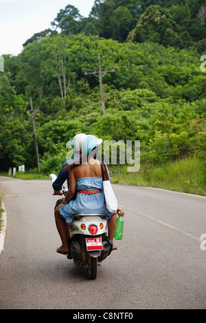 Couple riding scooter in remote area Banque D'Images