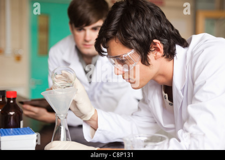 Étudiants en chimie faisant une expérience Banque D'Images