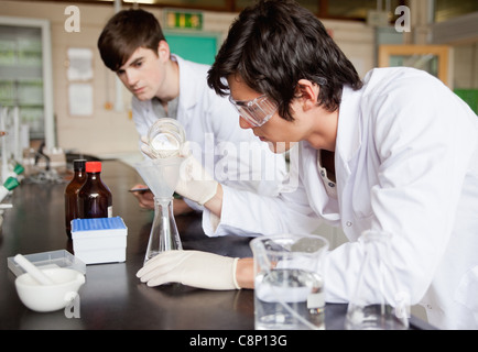 Les élèves de sexe masculin faisant une expérience de chimie Banque D'Images