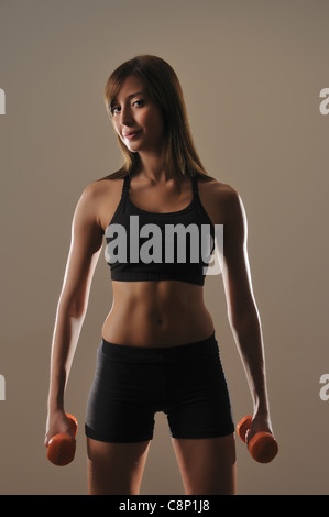 Jeune femme d'haltérophilie Banque D'Images