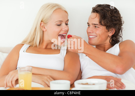 Bel homme donnant une fraise à sa petite amie Banque D'Images
