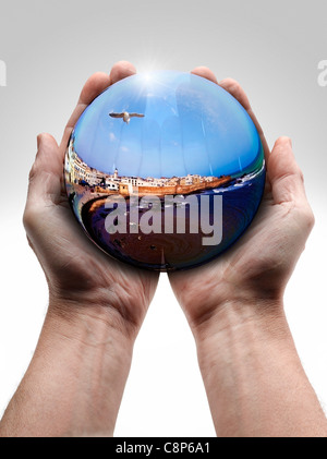 Homme main tenant une boule de cristal à l'intérieur du paysage Banque D'Images
