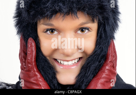 En hiver : portrait of smiling friendly natural woman black hat en fausse fourrure rouge avec des gants de cuir. Banque D'Images