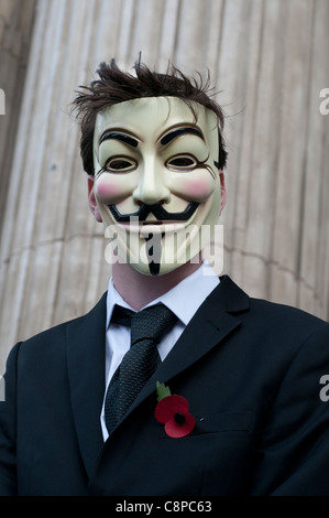 Occupy London Stock Exchange 29.10.2011.manifestant vêtu d'un costume, masque de Guy Fawkes et un coquelicot Banque D'Images