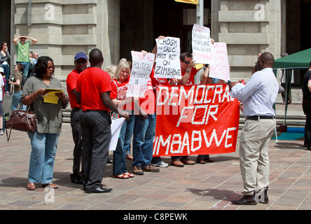 Des manifestants anti Mugabe tenant une "démocratie pour Zimbabwe" bannière au CHOGM 2011 manifestations à Perth. Banque D'Images