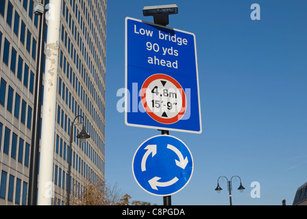 La signalisation routière indiquant un faible pont et un rond-point devant, à New Malden, Surrey, Angleterre Banque D'Images