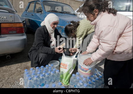 Épicentre du tremblement de terre de mai à Tabanlı Village et mesuré 7,2 sur l'échelle de Richter a frappé la province de Van, à 13:41 le 23 octobre 2011. Le séisme et ses répliques ont été ressenti principalement dans les régions voisines de l'épicentre. Une mère et sa fille de recueillir l'eau d'Croix Rouge turc je point de distribution Banque D'Images