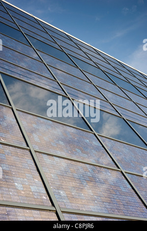 L'énergie solaire photovoltaïque panneaux électriques montés à l'intérieur d'une façade de l'immeuble en verre. Banque D'Images