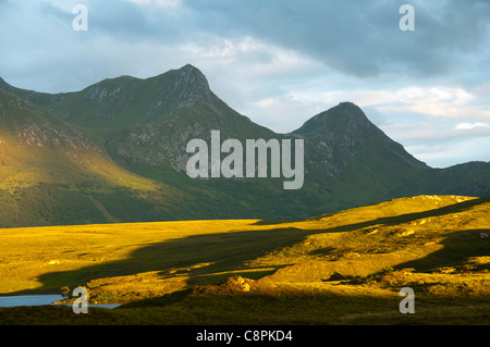 Ben Loyal près du coucher du soleil, au-dessus de Lochan Hakel, Sutherland, Écosse, Royaume-Uni. Banque D'Images