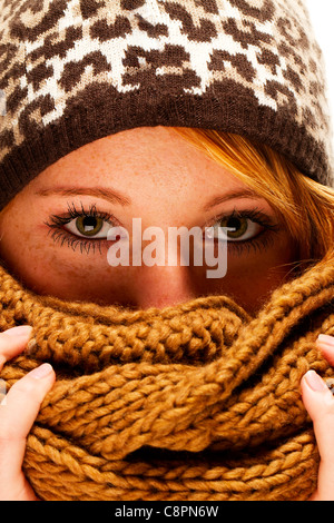 Jeune femme rousse avec écharpe de mode d'hiver se cacher derrière Banque D'Images