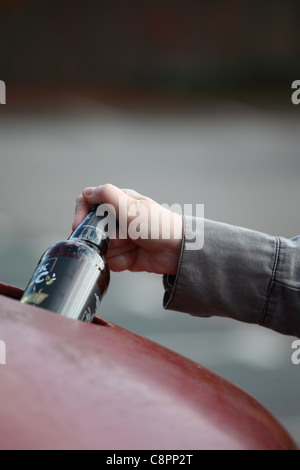 Woman's hand mise en bouteille recycling bin Banque D'Images