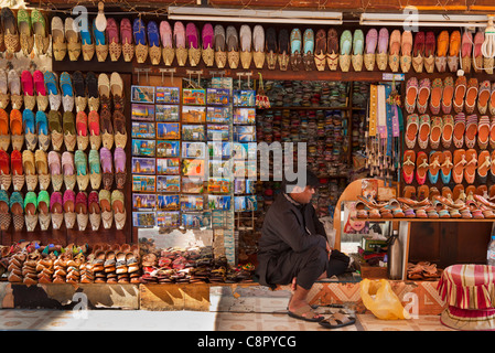 L'homme assis à son magasin qui vend des chaussures traditionnelles arabes, Bur Dubai, Émirats arabes unis, ÉMIRATS ARABES UNIS, Moyen Orient Banque D'Images