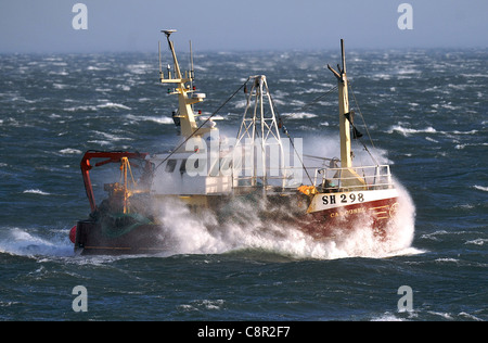 Un bateau de pêche par le biais de forts vents têtes tom Scarborough Harbour Banque D'Images