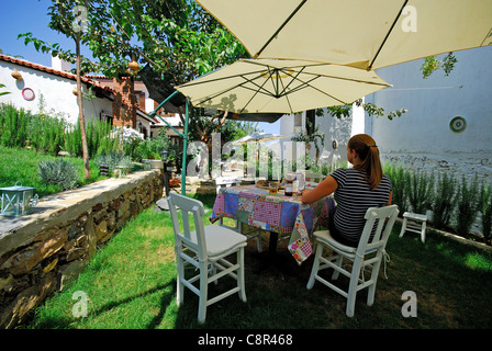 La Turquie. Une femme se détendre dans les jardins de l'Dionysos Pension, un boutique hôtel de luxe dans le village sur une colline de Sirince. Banque D'Images