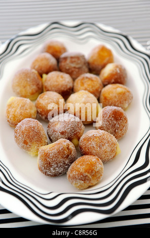 Boules de pâte Frites enrobées de sucre sur une plaque et conçu missoni nappe. Banque D'Images