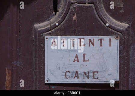 Un panneau d'avertissement pour un chien indiquant 'Attenti al Cane" en italien, où quelqu'un au crayon 'Gatto' à Chianciano Terme, Italie. Banque D'Images