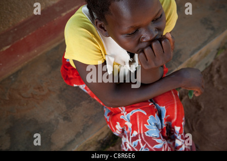 Une femme assise à l'extérieur un abri dans la violence domestique, l'Ouganda, district de Pallisa Afrique de l'Est. Banque D'Images