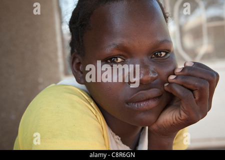 Une femme assise à l'extérieur un abri dans la violence domestique, l'Ouganda, district de Pallisa Afrique de l'Est. Banque D'Images