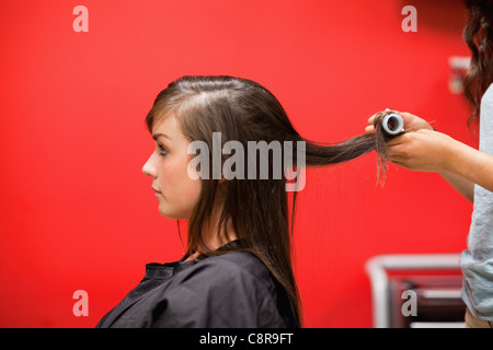 Jeune femme ayant les cheveux roulés Banque D'Images