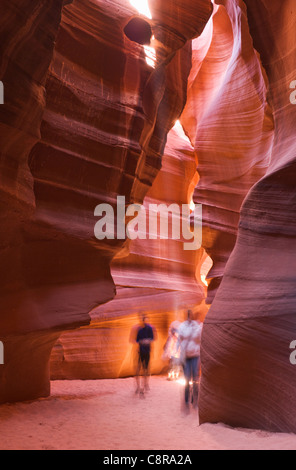 Les touristes visitant inhabituelle, des formations de roche orange dans cave Banque D'Images