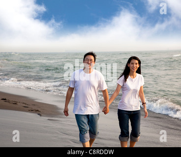 Heureux couple d'âge moyen marche sur la plage Banque D'Images