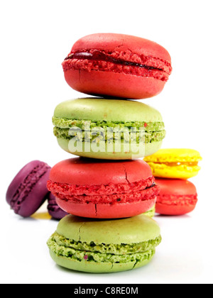 Pile de macarons pistache et fraise avec quelques macarons de derrière et un fond blanc Banque D'Images