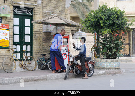 L'Afrique, Tunisie, Tozeur. Ravitaillement en hommes tunisiens un cyclomoteur à une petite station d'essence pour voiture à Tozeur. Banque D'Images