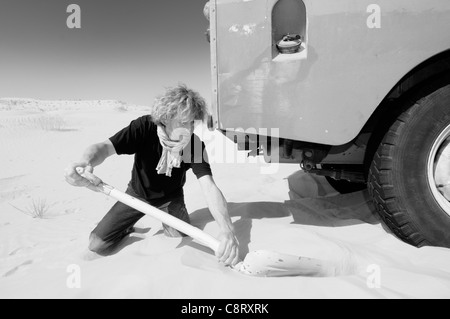 L'Afrique, Tunisie, nr. Tembaine. Voyageur du désert est resté coincé avec sa 1975 Land Rover Series 3 Station Wagon tout en ... Banque D'Images