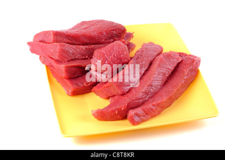Matières premières fraîches Pavé de boeuf sur une plaque jaune, fond blanc Banque D'Images