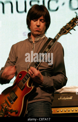 Mark Collins, de du groupe de rock anglais, The Charlatans à jouer de la guitare à un concert de HMV Oxford Street à Londres. Banque D'Images