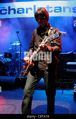 Mark Collins, de du groupe de rock anglais, The Charlatans à jouer de la guitare à un concert au London's Shepherd's Bush Empire Banque D'Images